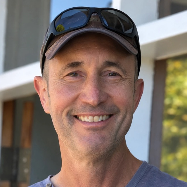 Michael Nees, smiling, in a cap with sunglasses pushed up